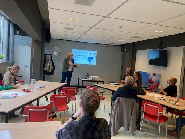 mensen vergaderen en Rixt houdt een presentatie