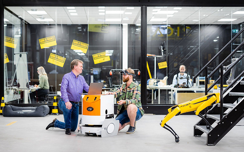 Erik Fledderus samen met onderzoeker bij een cobot